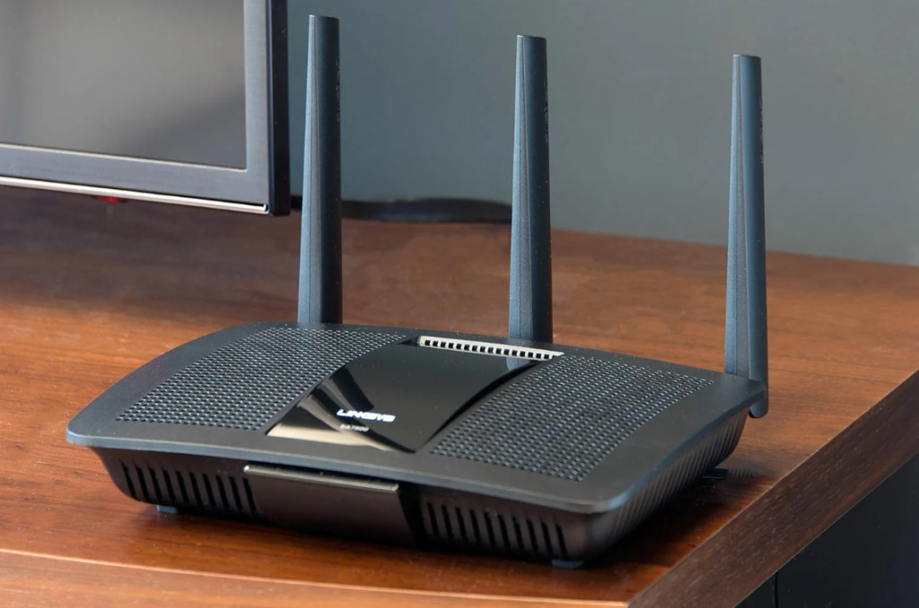 Черный роутер с антеннами стоит на столе